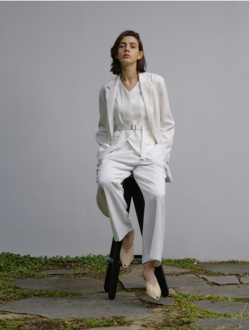 白いJacket、Gilet、Pantsを着用して椅子に座ってる女性の画像