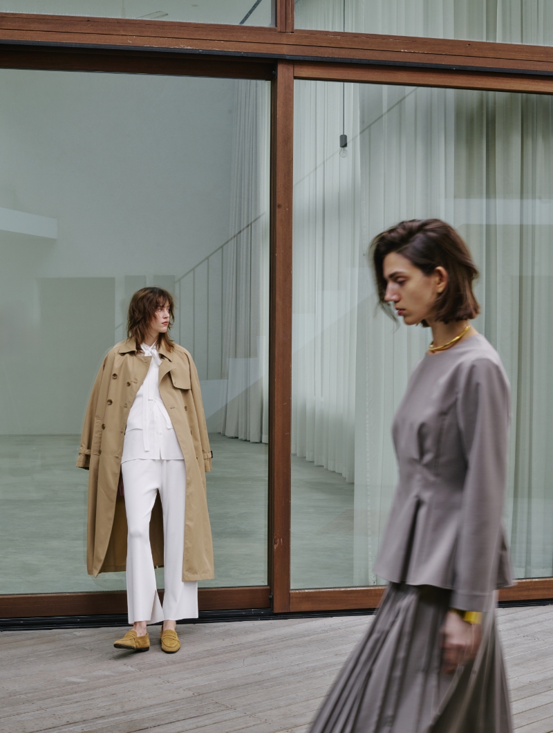 左側にロングトレンチコートを着用した女性と右側にウォッシャブルペプラムブラウスとプリーツスカート【CLEAN MOTION】を着用した女性の画像