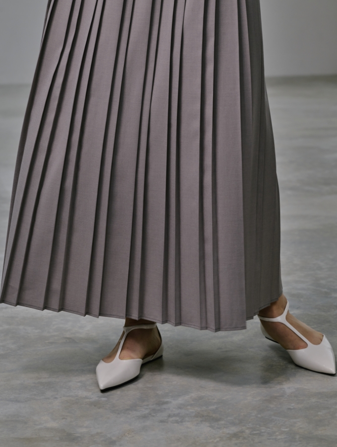 グレージュ色のウォッシャブルペプラムブラウス【CLEAN MOTION】とプリーツスカート【CLEAN MOTION】を着用した女性の画像03