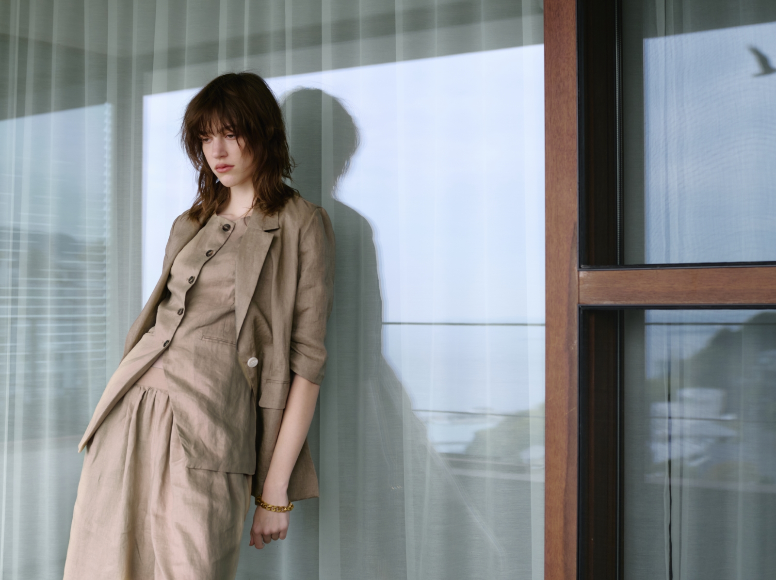 4月に公開するベージュ色のJacketとGilet、Pantsを着用した女性の画像