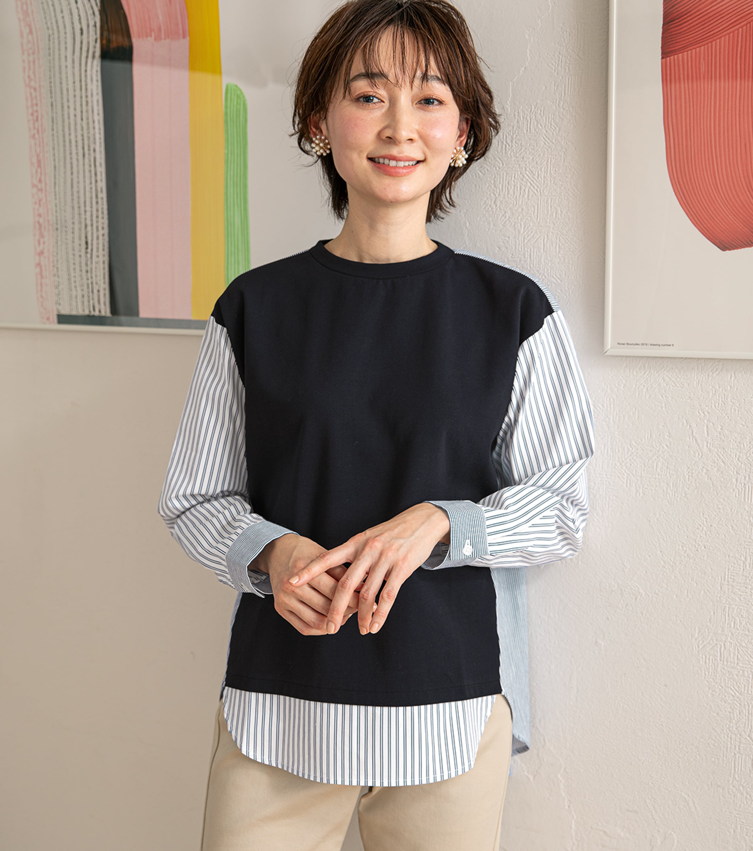 一枚で着映えする重ね着風の変わり種デザイン ストライプ切替ブラウス・ネイビーを着用している女性の写真