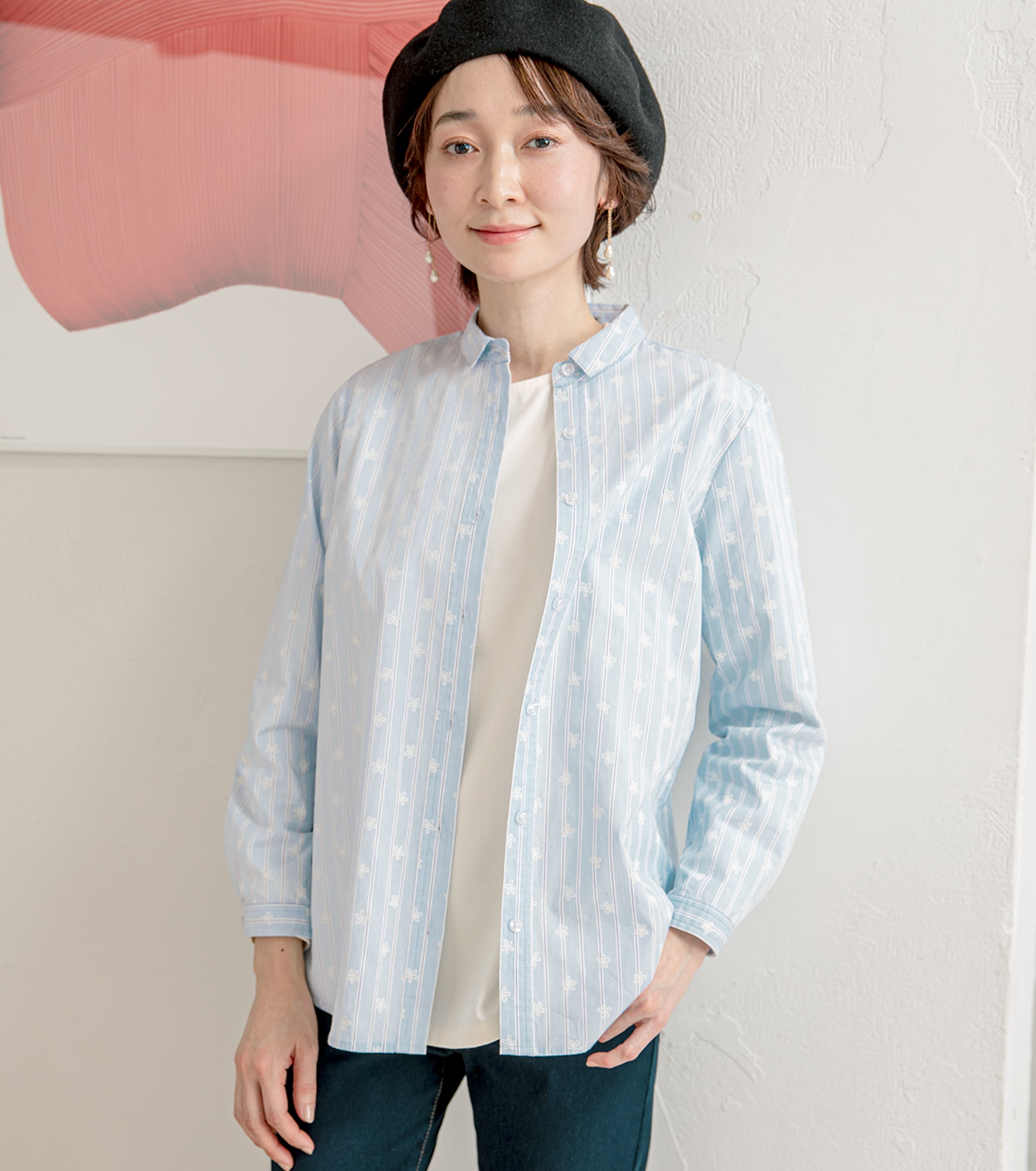 シャツ羽織りの軽快コーデで春っぽく ストライププリントシャツ・サックスを着用している女性の写真