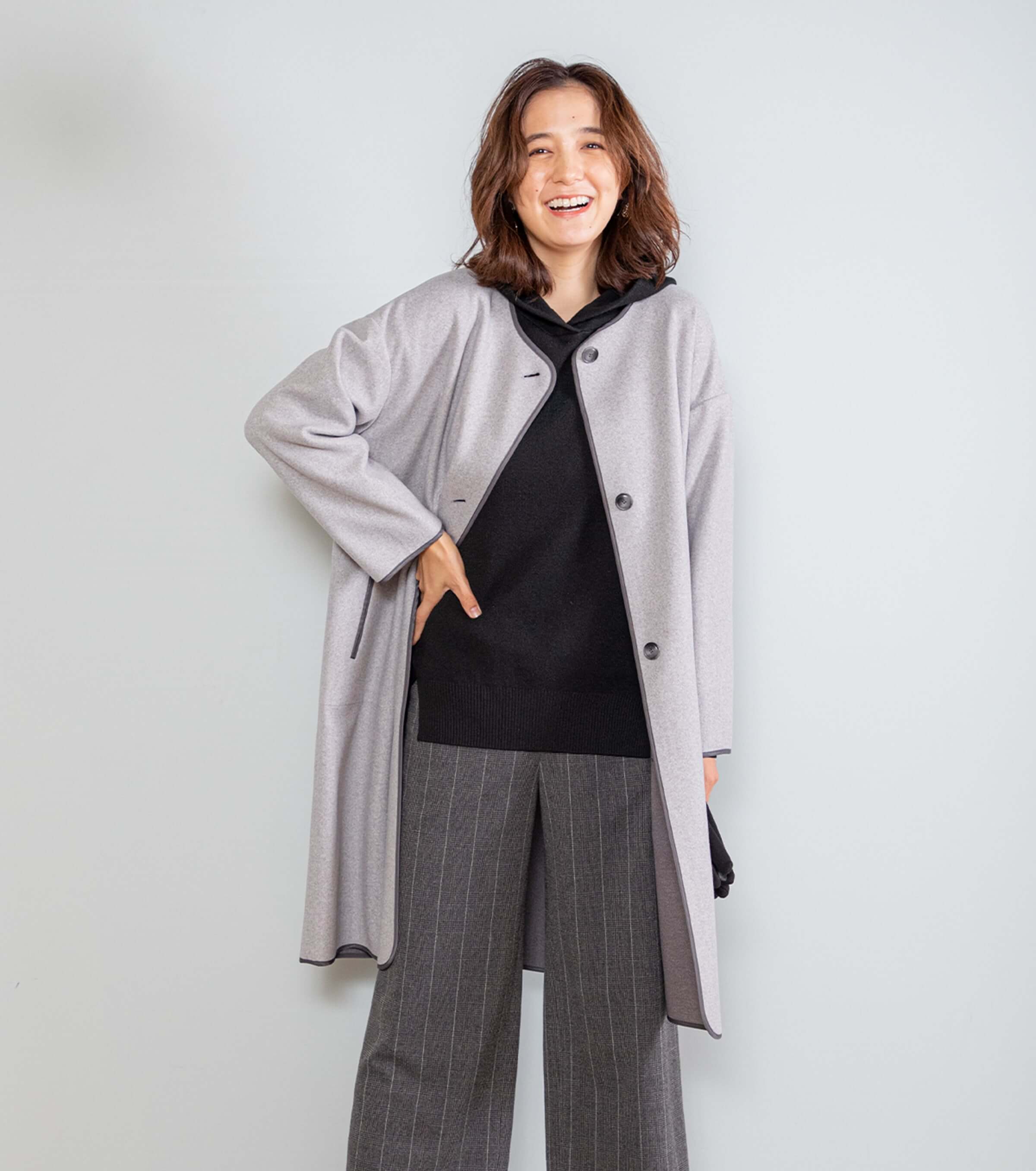 ネイビーのニットパーカーをコートからチラ見せ